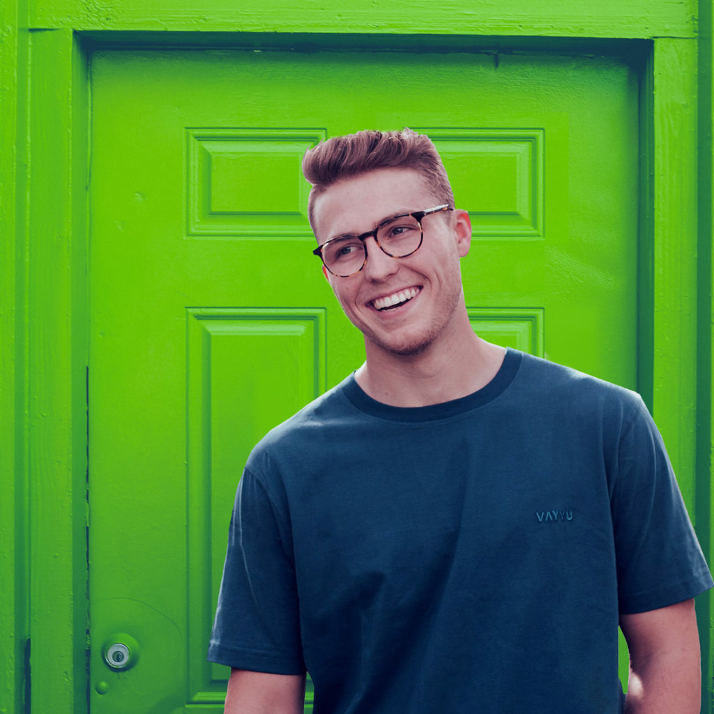 laughing man in front of a green door