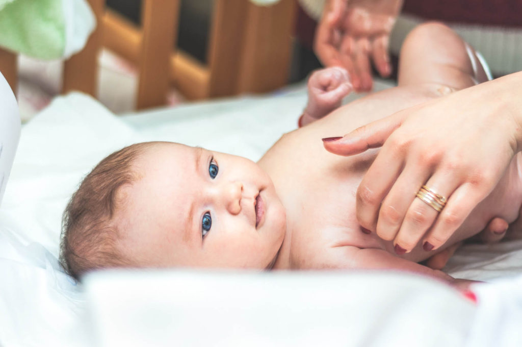 Infant lying down comforted by mother